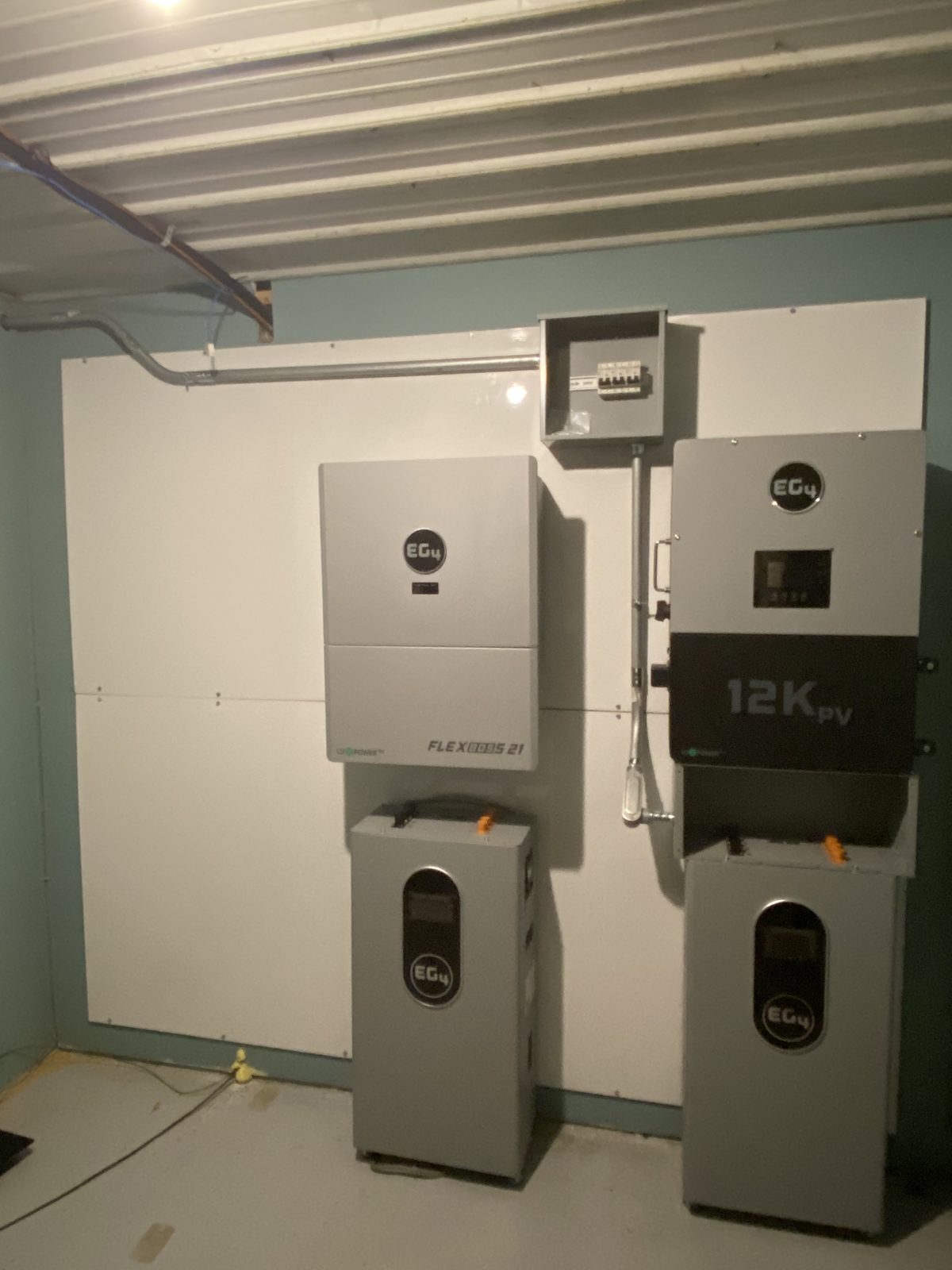 Two hybrid inverters and battery cabinets mounted on a wall