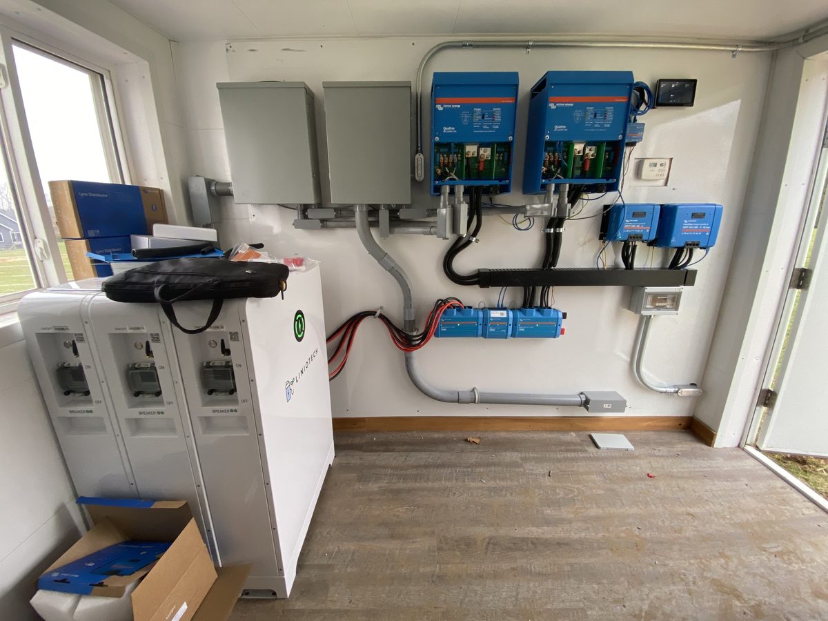 Finished off-grid power room with inverters, charge controllers and battery
