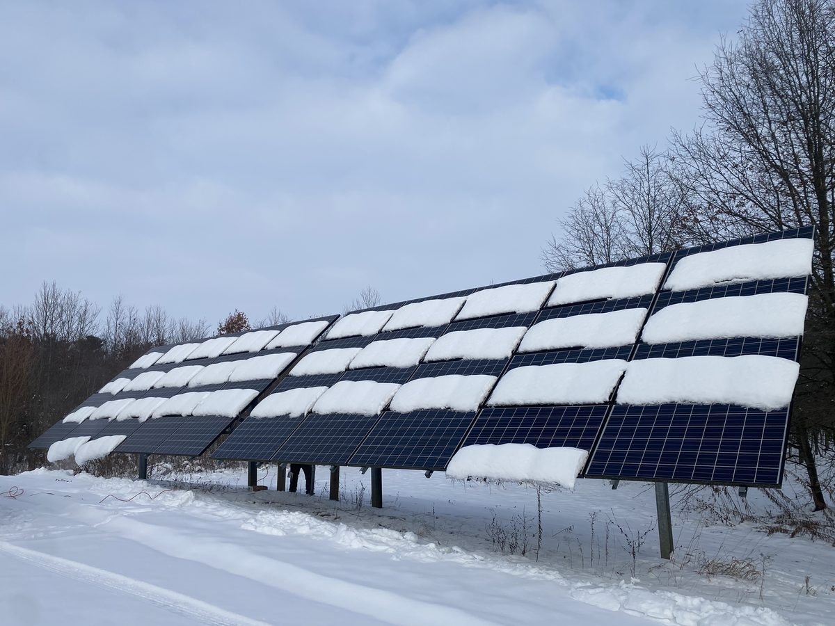 Snow-covered ground mount solar array in winter