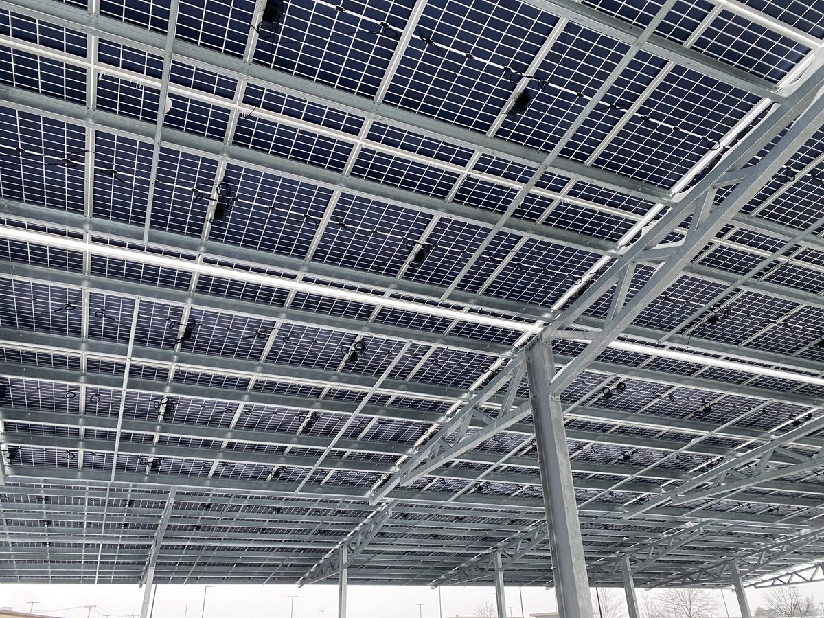 Underside of a solar carport showing module framing and wiring