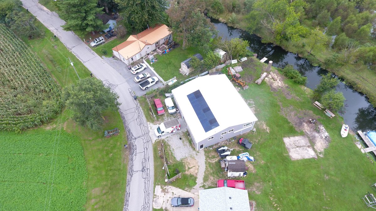 Overhead drone view of a pole barn solar system and the surrounding property