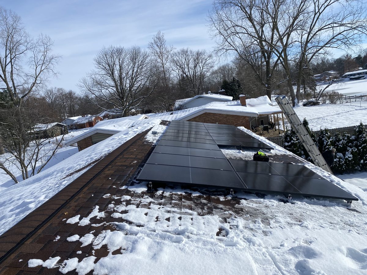 Solar panels installed on a snow-covered roof in winter