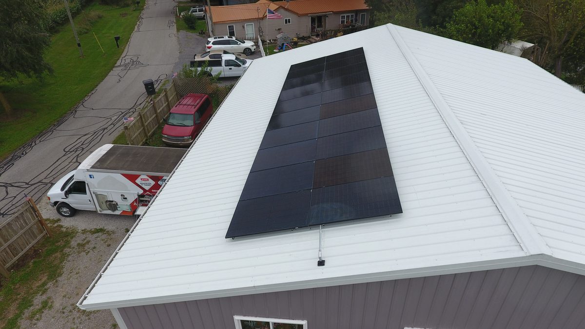 Aerial view of solar panels on a white metal pole barn roof