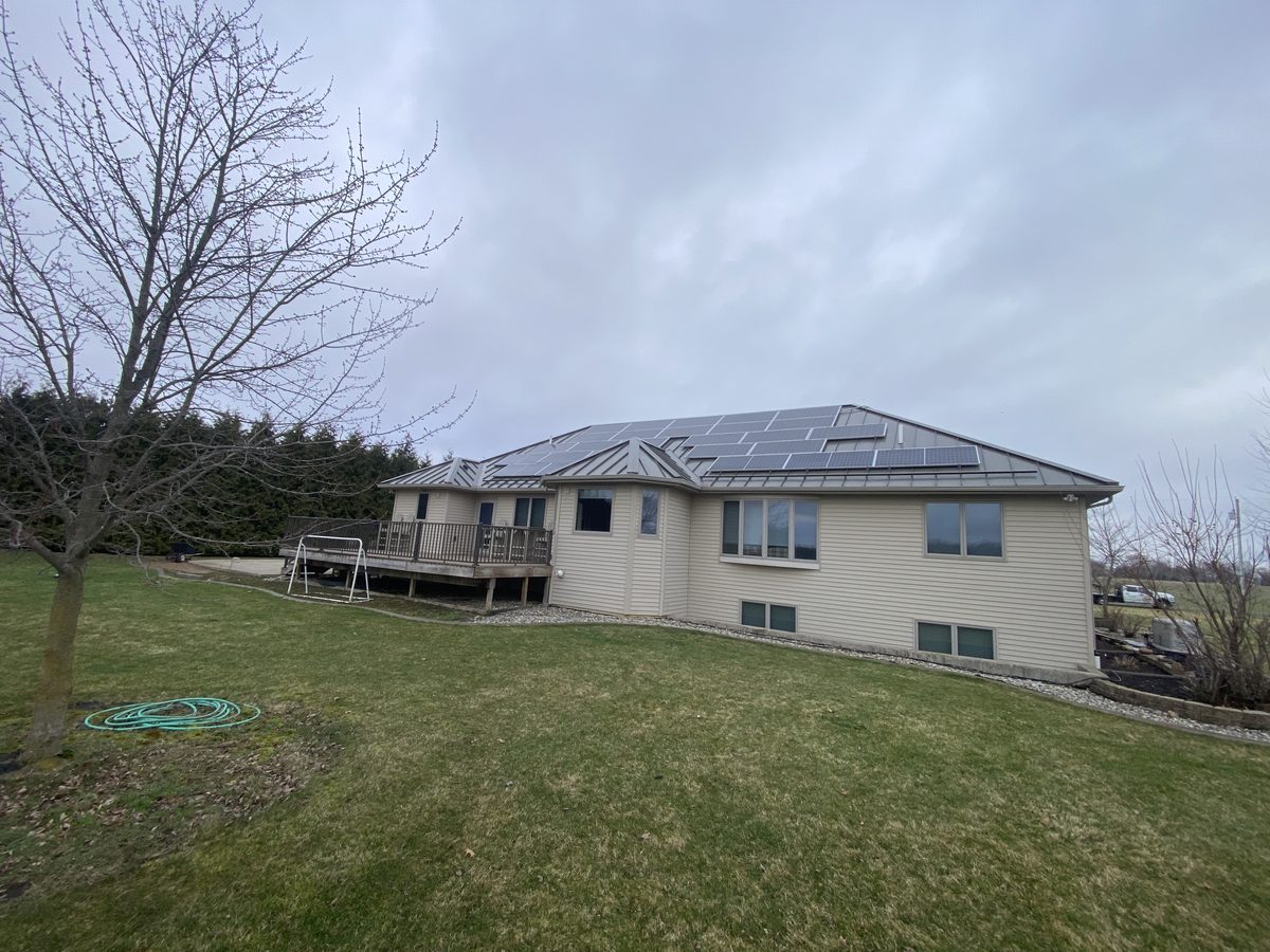 Solar panels covering a standing seam metal hip roof