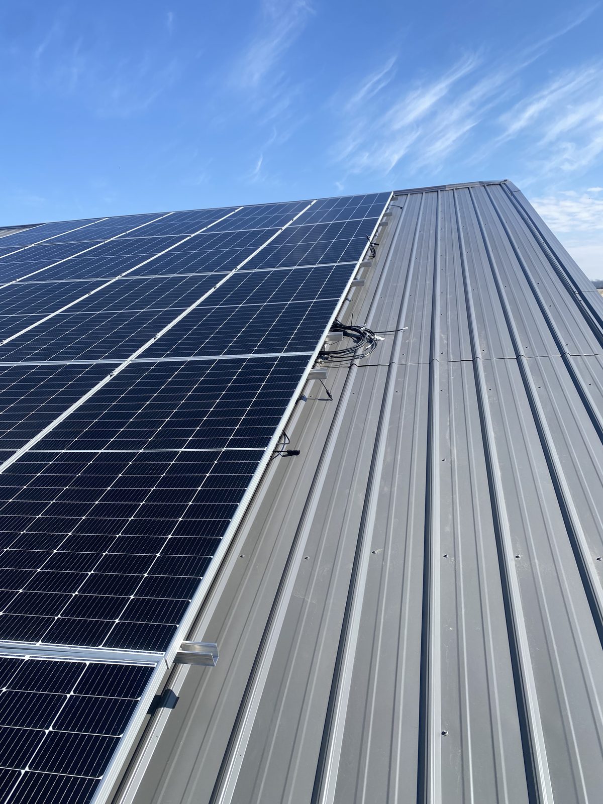 Rail and module detail on a corrugated metal barn roof